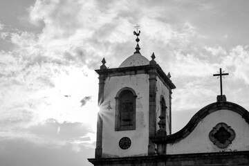 Sunrise or sunset behind a church bell tower in black and white
