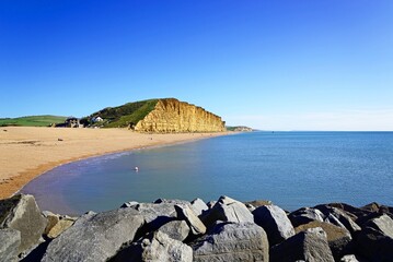 View over the rocks towards the beach and Jurassic Coast cliffs, West Bay, Dorset, UK, Europe.