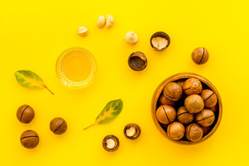 Bowl of of macadamia nuts oil with raw nuts. Natural oil for cosmetic or cooking
