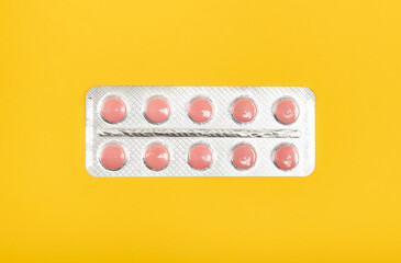 Blister of pills isolated on yellow.