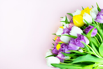 Bouquet of colorful tulips on pink background. Mothers day, Valentines Day, Birthday celebration concept. Greeting card. Copy space for text, top view.