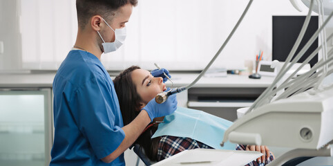 Obraz premium Dentist treats teeth of patient