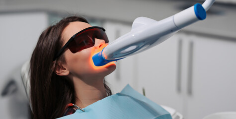 Teeth whitening for woman. Bleaching of the teeth at dentist clinic.