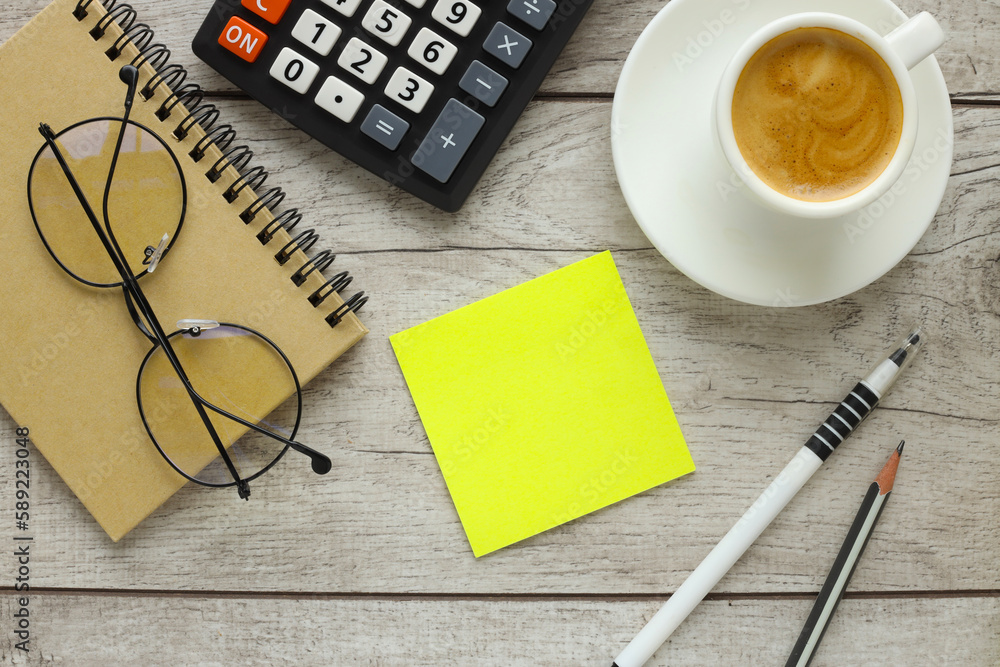 Poster top view of color yellow working table background with blank paper notebook, cup of coffee, laptop. 