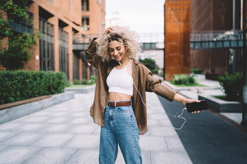 Carefree African American female dancing on street