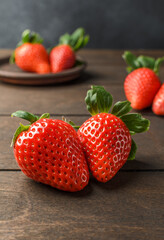 Juicy strawberry on a dark wood background is the concept for any kind of diet and healthy eating. Closeup