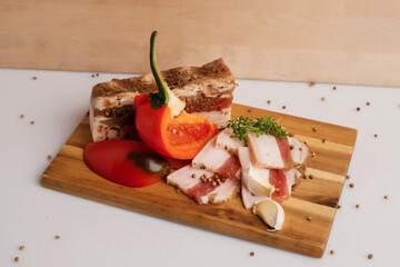Bacon with pepper and salt on a wooden board