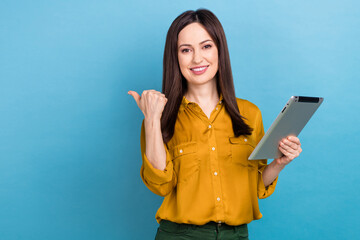 Photo of young secretary company broker lady wear yellow shirt hold ebook gadget direct finger empty space sale isolated on blue color background