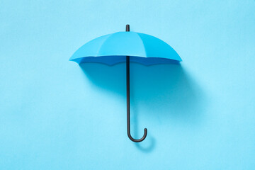 Blue umbrella isolated on blue background © Kenishirotie
