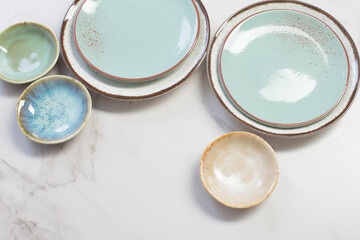 assorted ceramic plates on white marble table