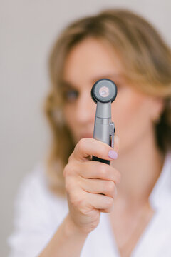 Woman doctor holding dermatoscope equipment for skin examination