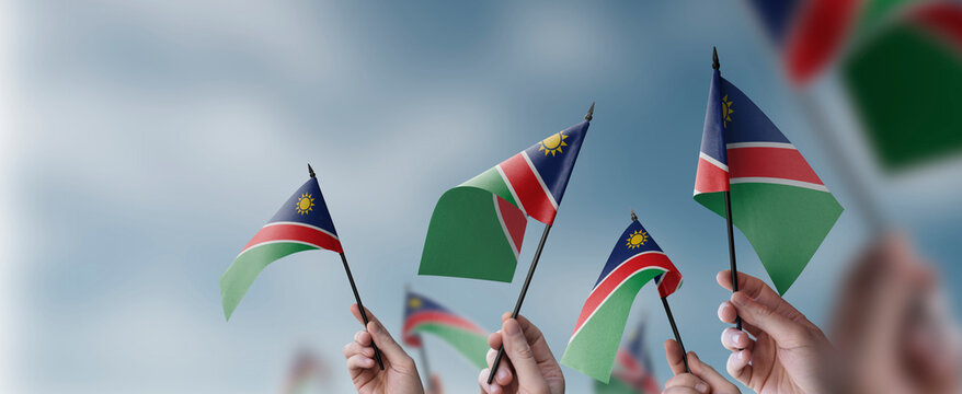 A group of people holding small flags of the Namibia in their hands