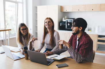 Positive diverse colleagues working on new project together in office