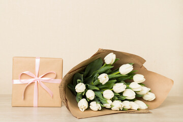 Obraz na płótnie Canvas White tulip bouquet with gift box on table