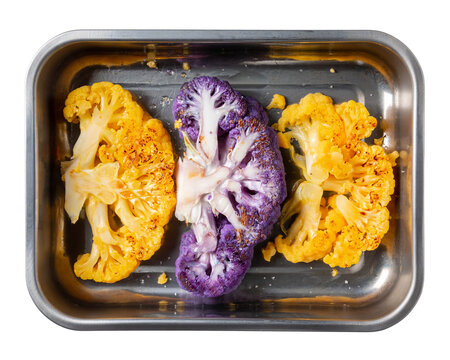 Vegetable colorful cauliflower steaks on metal baking sheet isolated on white. Сooking vegan or vegetarian meal. Healthy plant based food. Top view.
