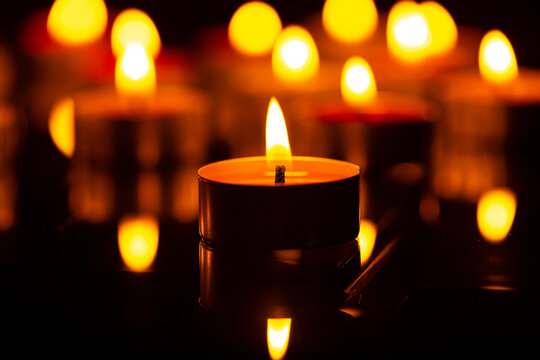 candle,Burning candles on a dark memorial day surface,Many burning candles with a shallow depth of field. - Powered by Adobe