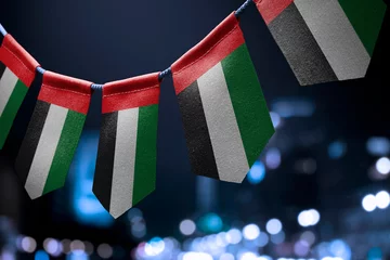 Foto op Canvas A garland of United Arab Emirates national flags on an abstract blurred background © butenkow
