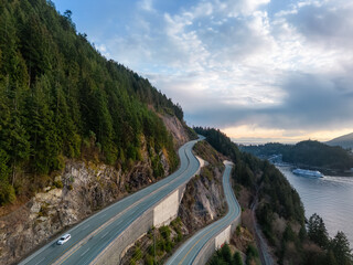 Obraz premium Aerial View of Sea to Sky Highway in Howe Sound. Sunset Sky. Between Squamish and Vancouver, BC, Canada.