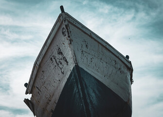 The old fishing boat creaks as it bobs gently on the tranquil waters. Its weathered planks tell the story of countless voyages, of battles fought against the elements.