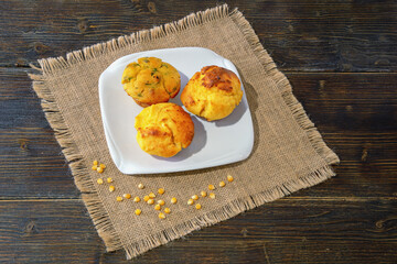 Balkan cuisine. Proja -  dish made of corn flour.  Cornbread, prepared as a muffin , on white plate. Dark rustic table, corn grains