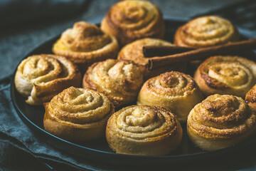 Cinnamon rolls on a black table on dark background