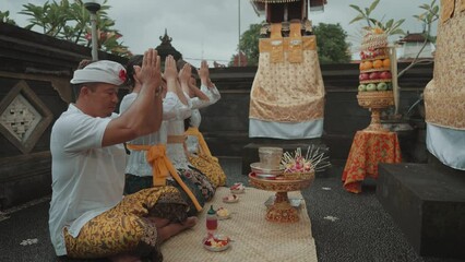 Balinese Family Performing Hindu Ritual Prayer Daily Offerings at Home Temple in Bali Indonesia Culture Religion