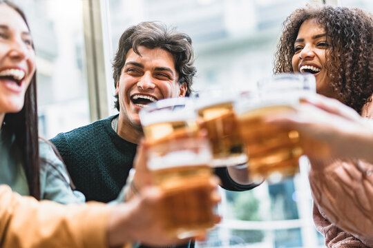 Multiracial Friends Drinking Beer Glasses Sitting At Brewery Pub- Young Group Of Happy People Having Fun Toasting Pint At Bar Enjoying Happy Hour Time- Life Style Food And Beverage Concept With Guys