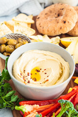 Hummus bowl with vegetables, fruits, olives, pita and crackers.