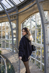 Fototapeta premium Young woman in botanical garden. She explore different types of trees. Botany, arboretum, hortus botanicus in amsterdam, netherlands.
