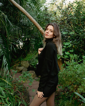 Young beautiful woman in botanical garden. There is plenty of green plants.