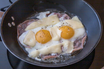 Hemenex from two eggs in a pan. Eggs with salami and cheese. Good breakfast.