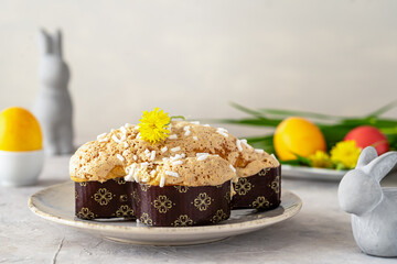 Italian Easter cake Colomba on plate with easter decoration of colored eggs, rabbits and wild flowers