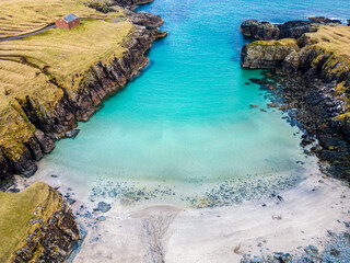 Aerial drone view of Port of Stoth on the Isle of Lewis. Turquoise sea water.