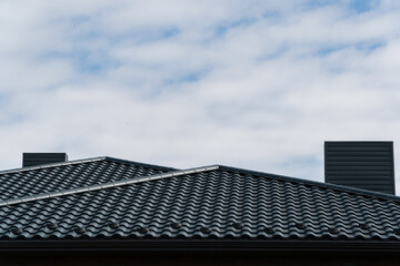 Fototapeta na wymiar Modern roof of the house made of metal profile. Modern roof made of metal