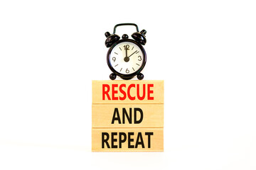 Rescue and repeat symbol. Concept words Rescue and repeat on wooden block on a beautiful white table white background. Black alarm clock. Business rescue and repeat concept. Copy space.
