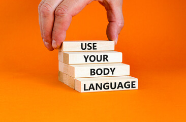 Use your body language symbol. Concept words Use your body language on wooden block. Beautiful orange table orange background. Motivational business use your body language concept. Copy space.