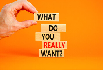 What do you really want symbol. Concept words What do you really want on wooden block. Beautiful orange table orange background. Businessman hand. Business what do you really want concept. Copy space.