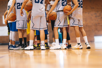 Junior Basketball Team During Training Class Standing Together and Huddling in Circle. Players...