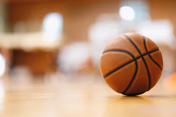Fotobehang Close-up image of basketball ball over floor in the gym. Orange basketball ball on wooden parquet. © matimix