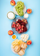 Jewish Shavuot Holiday Card. Dairy Products, Grapes, Cheese, Bread, Milk on Blue Background.