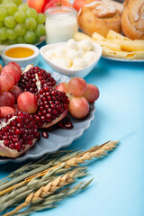 Jewish Shavuot Holiday Card. Dairy Products, Grapes, Cheese, Bread, Milk on Blue Background.