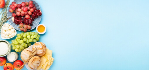 Jewish Shavuot Holiday Card. Dairy Products, Grapes, Cheese, Bread, Milk on Blue Background.
