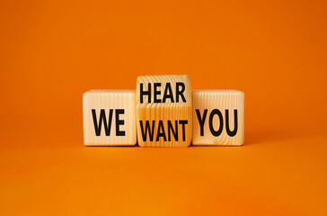 We hear and want You symbol. Tturned wooden cubes with words We want you and We hear you. Beautiful orange background. Business and We hear and want You concept. Copy space