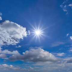 Naklejka na ściany i meble sparkle sun on dense cumulus clouds background