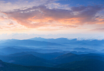 twilight mountain ridge silhouette in blue mist