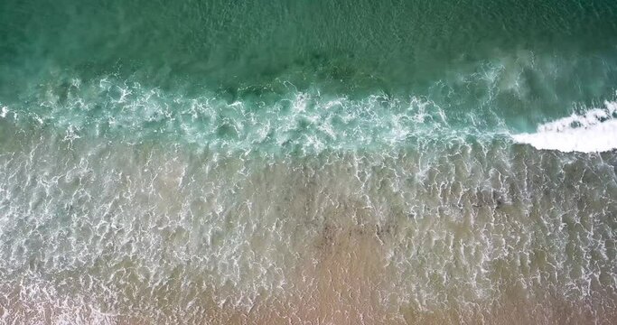 Abstract aqua water, waves and beach perspective smooth drone decent 