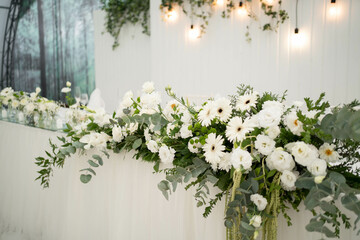 Wedding decoration table in the hall, floral arrangement. In the style vintage. Decorated dining table with flowers for guests and newlyweds, in white color.
