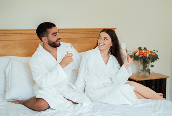 Romantic Multiethnic Couple Drinking Sparkling Wine Having Date In Hotel