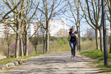 Fototapeta na wymiar Adult sportive woman jogging in the autumn park