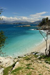Kassiopi beach ,Corfu island, Greece- The beautiful turquoise water and beaches around a small town on the Northern side of the island with Albania in the distance in Spring.